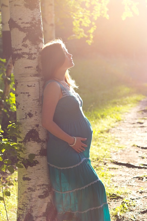 Těhotná žena v modrých šatech